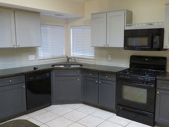 Kitchen with brand new granite counters and glass backsplash