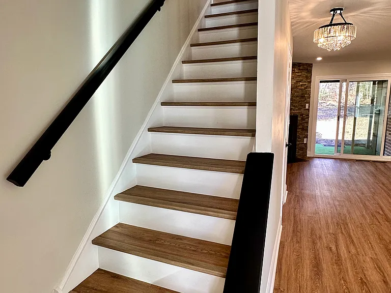 Elegant wood staircase connecting living and bedroom levels_enhancing the home's character and creating a seamless, stylish flow.