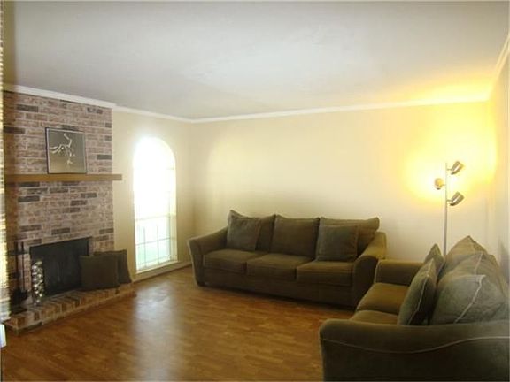 Large living area with fireplace and laminate floors throughout condo