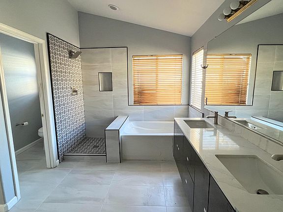 Master bathroom with two-sinks, big tub, shower, and separate toilet room.