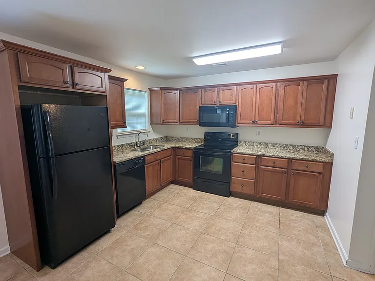 Kitchen with Kraftmaid cabinets, granite countertops, microwave, oven, dishwasher, and fridge