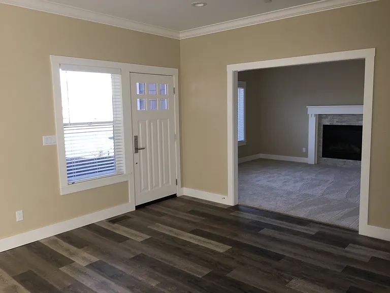 Family room with carpeted living room with gas fireplace.