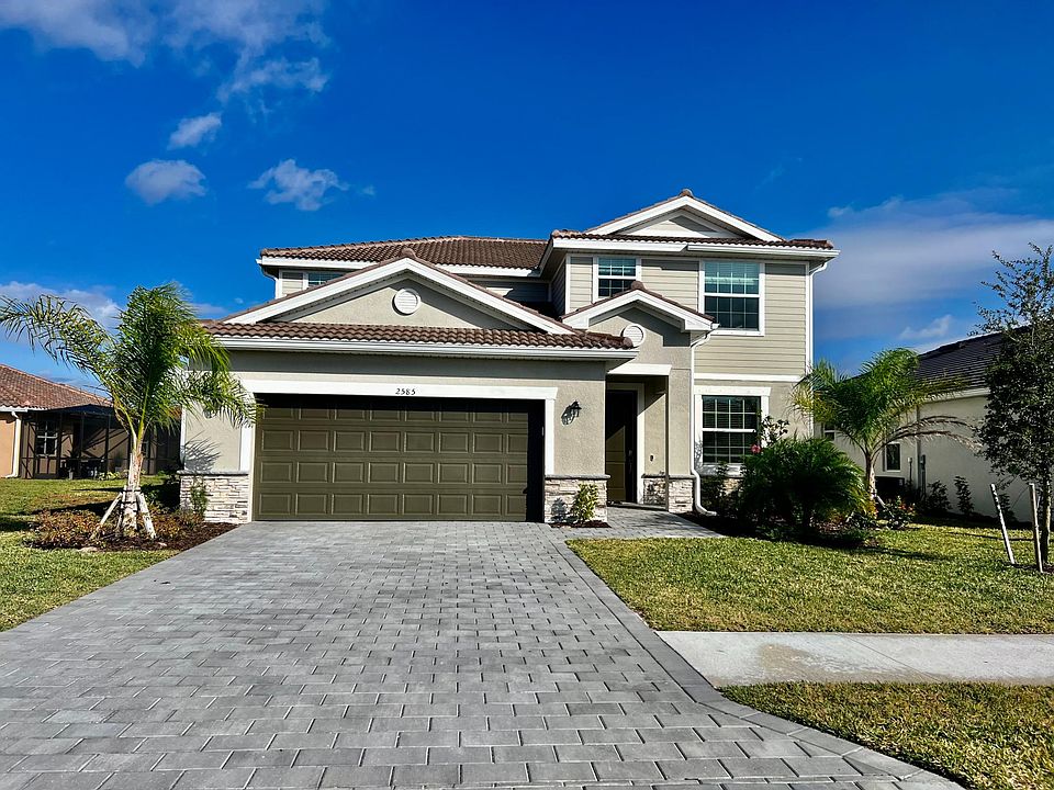 Front facade. House features 2 car garage and extra long paver driveway.