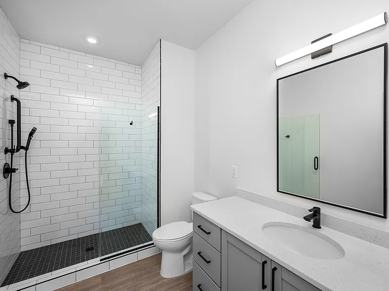 Modern bathroom featuring a sleek glass-enclosed shower, elegant vanity with a pristine countertop, and stylish subway tiles for a contemporary look. Modern bathroom featuring a sleek glass-enclosed shower, elegant vanity with a pristine countertop, and s