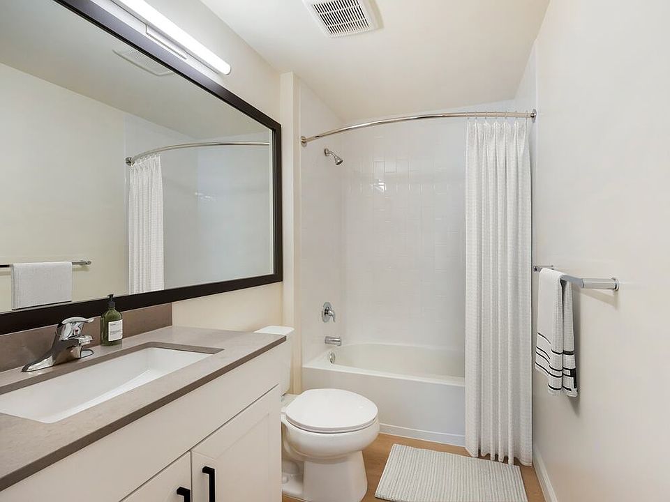 New Apartments bath with grey quartz countertop, white cabinetry, and hard surface flooring