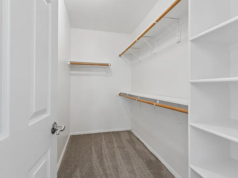 Walk in master closet with large shelving and hanging closet space; new carpet and paint