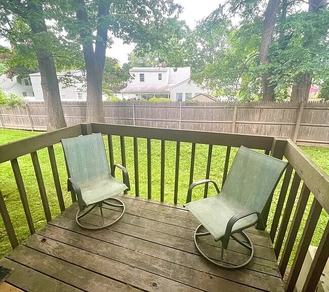 Private balcony overlooking a grassy outdoor area.