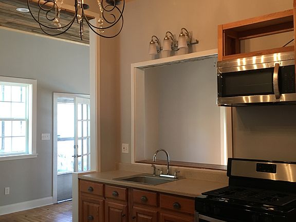 Original wood throughout ceiling and floors. Cypress repurposed cabinets. Sweet chandelier in kitchen.