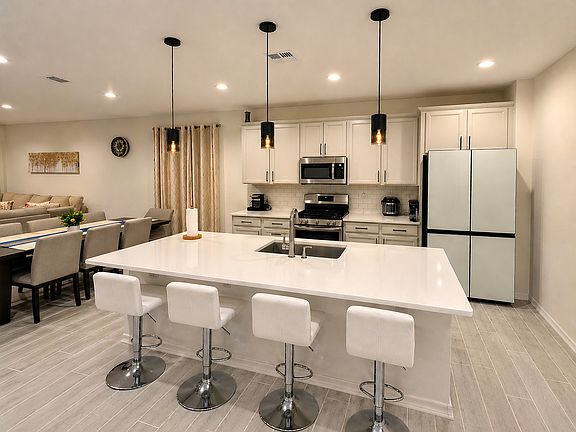 Stunning kitchen with large island, quartz countertops, modern pendant lighting, and Samsung Bespoke Refrigerator
