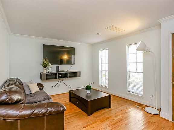 The living room is near the front door. The windows face North, which is ideal for sunlight to shine through all day. Beautiful hardwood floors.