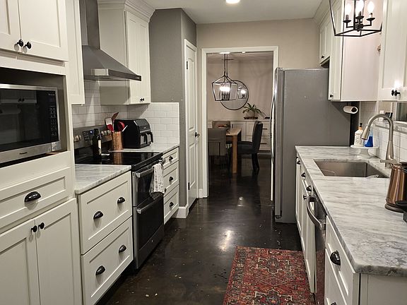 Galley Style kitchen with marble counters and custom cabinets with soft close doors and drawers!