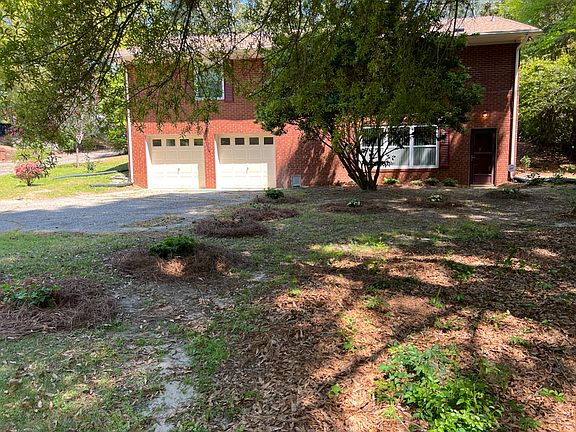 This picture shows the back of the house, the 2 car garage, and part of the back yard.