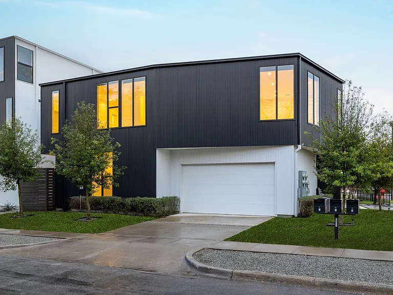 Modern architectural design featuring dark vertical siding and white accent panels