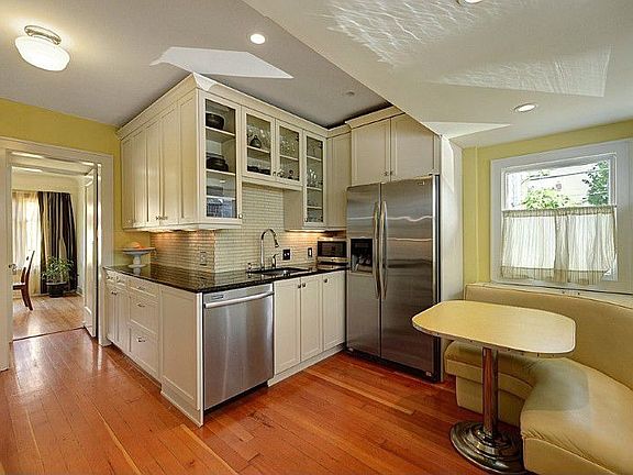 Beautifully renovated kitchen with sub way tile, slab granite counters, classic white cabinetry, stainless steel appliances plus in-kitchen breakfast nook.