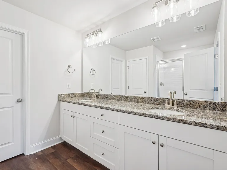 Primary bathroom with double vanity, walk-in shower and walk-in closet.