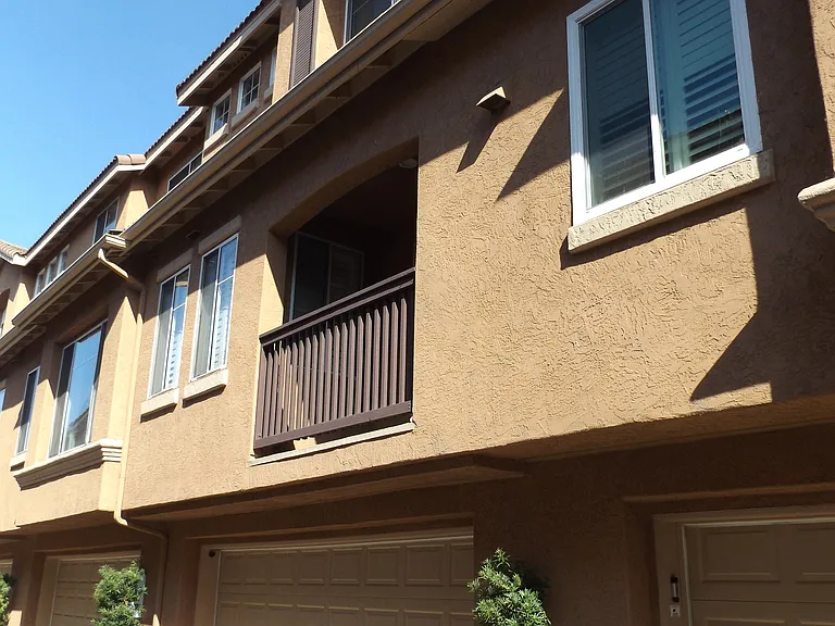 View of the townhouse and rear balcony from the drive aisle