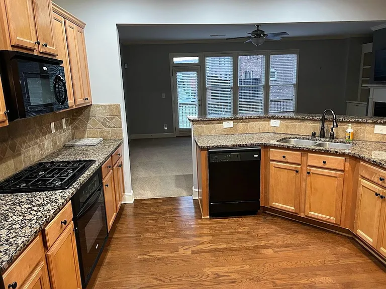 Kitchen facing living room opening to the deck. Kitchen has all appliances awith gas cooking range.
