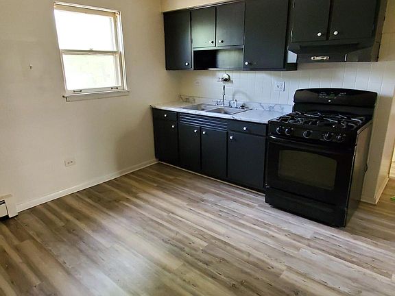Kitchen and dinette area. Flooring in light and dark gray colors.