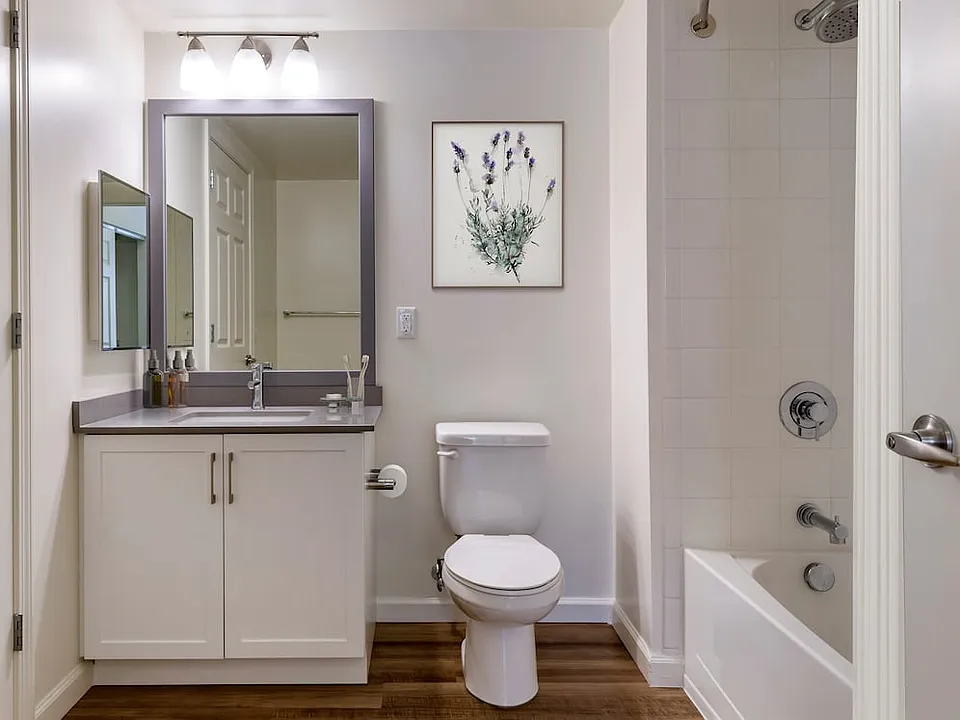 Renovated II bath with grey quartz countertops, white cabinetry, and hard surface flooring