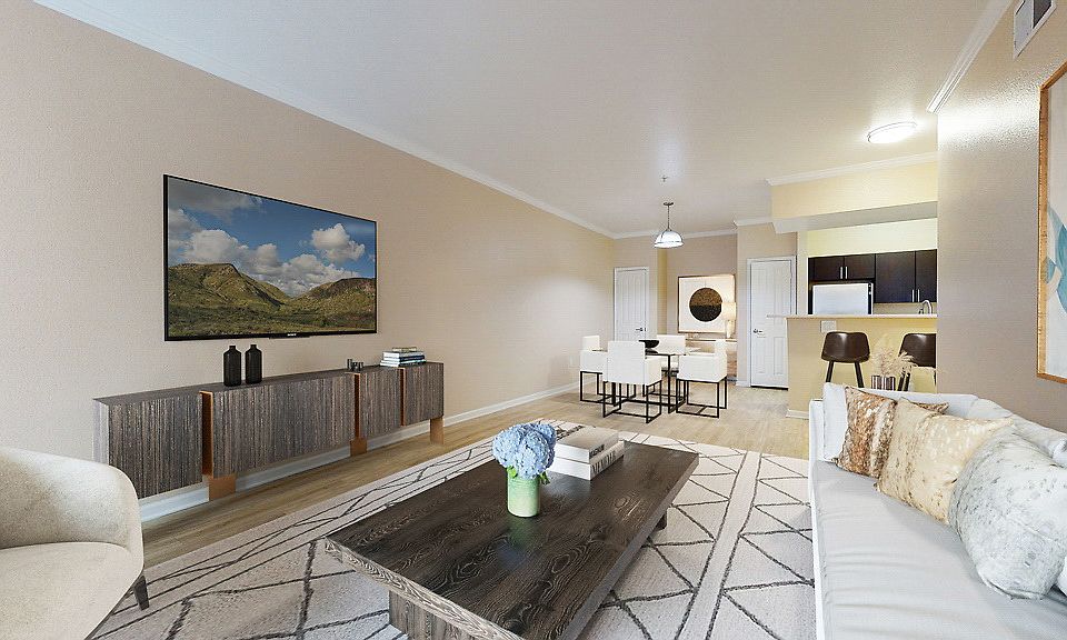 Staged living and dining area with hardwood style flooring. Kitchen with stainless steel appliances.