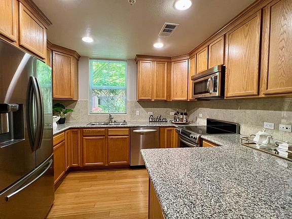 Kitchen with granite counter top. 
 All appliances S/S, including fridge, dishwasher, stove, microwave. In-sink garbage disposal.