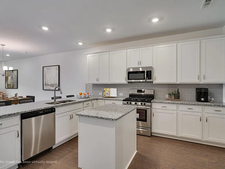Kitchen looking into LR and over large Breakfast bar. All new appliances including refrigerator. Staged photo