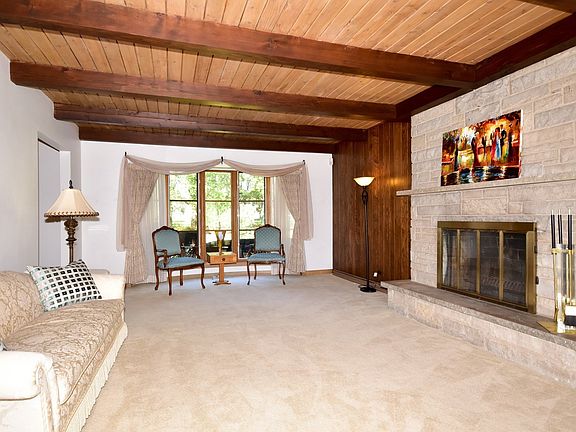 East/West facing with a lot of natural daylight in this room. One of three wood-burning fireplaces in the home.