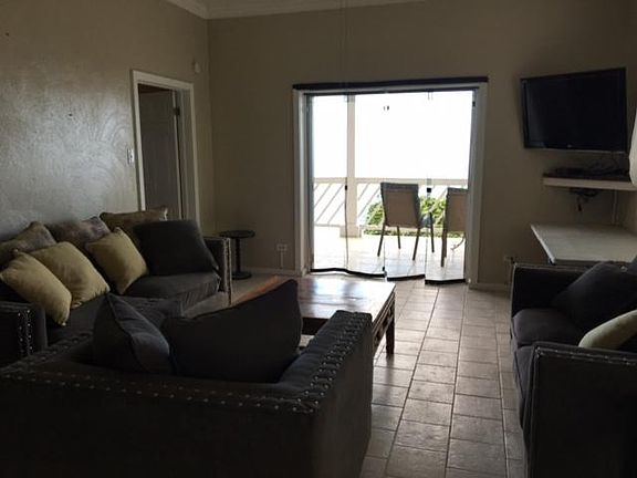 From kitchen entryway looking at living room and deck. First bedroom is through doorway on the left.