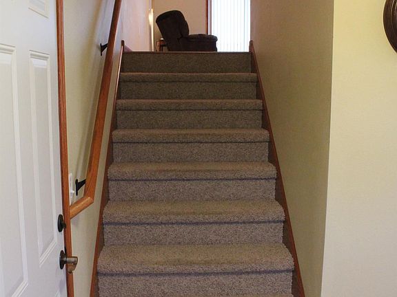 Stairway to upper level with garage door access on left