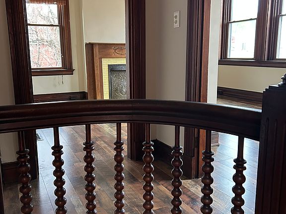 original woodwork spindles along the stairs, looking into the living area on the second floor