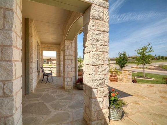 Stunning stone covered porch overlooking the beautifully landscaped front porch.
