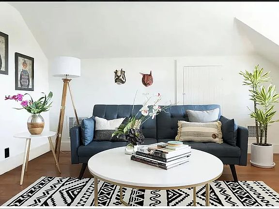 The living room currently holds a full-size sleeper sofa, chair, desk, bookcase, and credenza -- and still feels light and minimal.