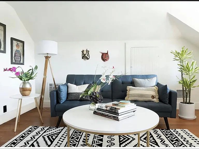 The living room currently holds a full-size sleeper sofa, chair, desk, bookcase, and credenza -- and still feels light and minimal.