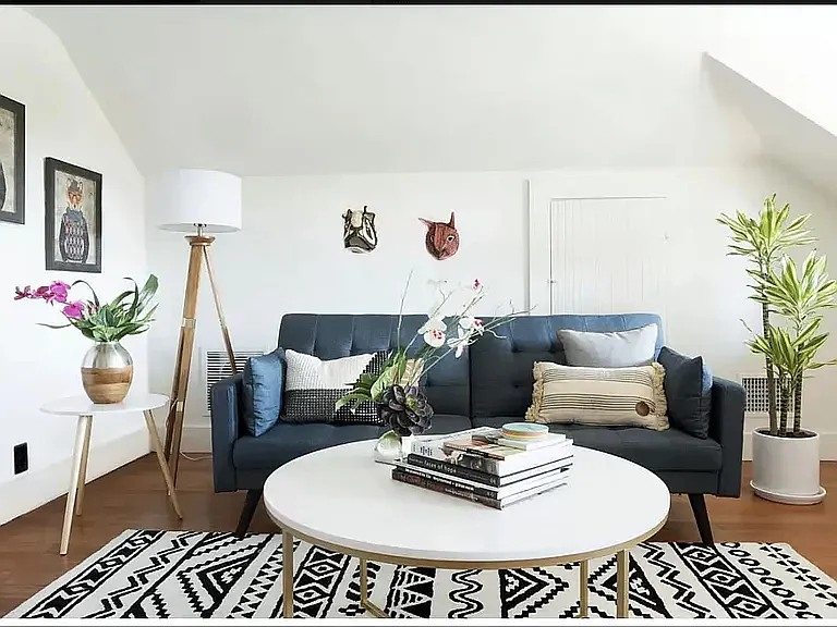 The living room currently holds a full-size sleeper sofa, chair, desk, bookcase, and credenza -- and still feels light and minimal.