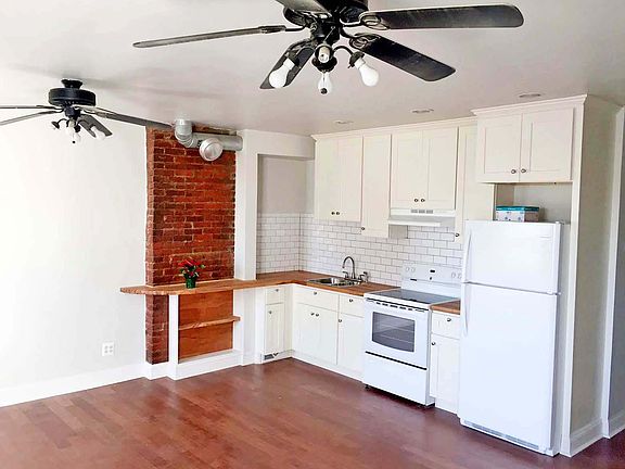 this open plan allows for an island, eat-in kitchen or stools by the brick for a computer/bar area