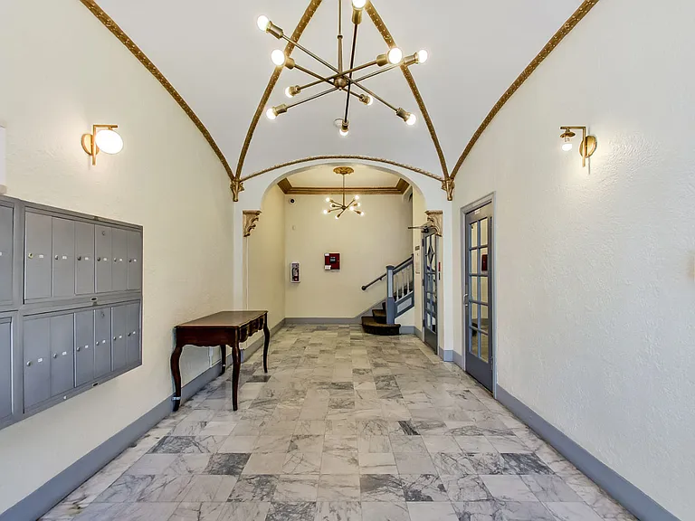 Hallway with a chandelier and mailboxes
