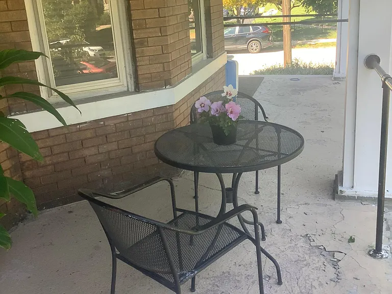 Front porch exclusively used by an apartment with wrought iron furniture