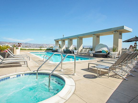 Swimming pool and spa with sundeck and lounge seating.
