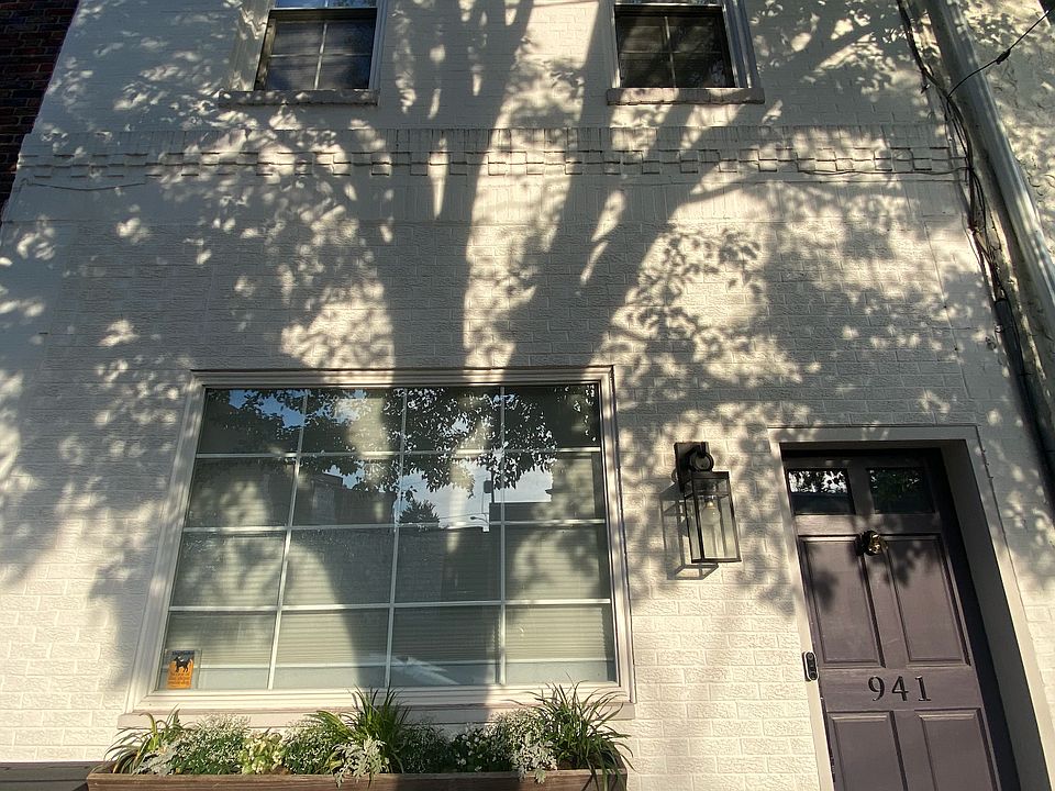 Two-story home with large planter and front-window boasting great natural light.