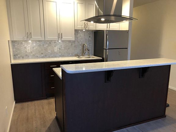 Dark cabinets below and white upper cabinets. Includes marble backsplash