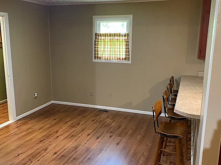 (1 of 2) Living room area with countertop seating adjoining kitchen.