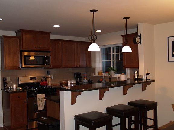 Kitchen off living room area with stainless steel appliances