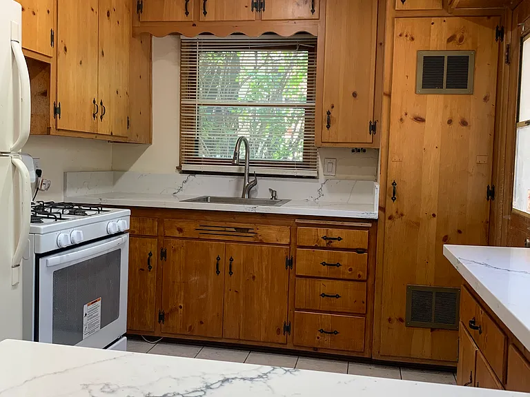 Kitchen with newly painted cabinets and new countertops/ sink