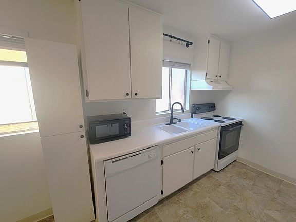 Large cabinets with matte black knobs and hinges.