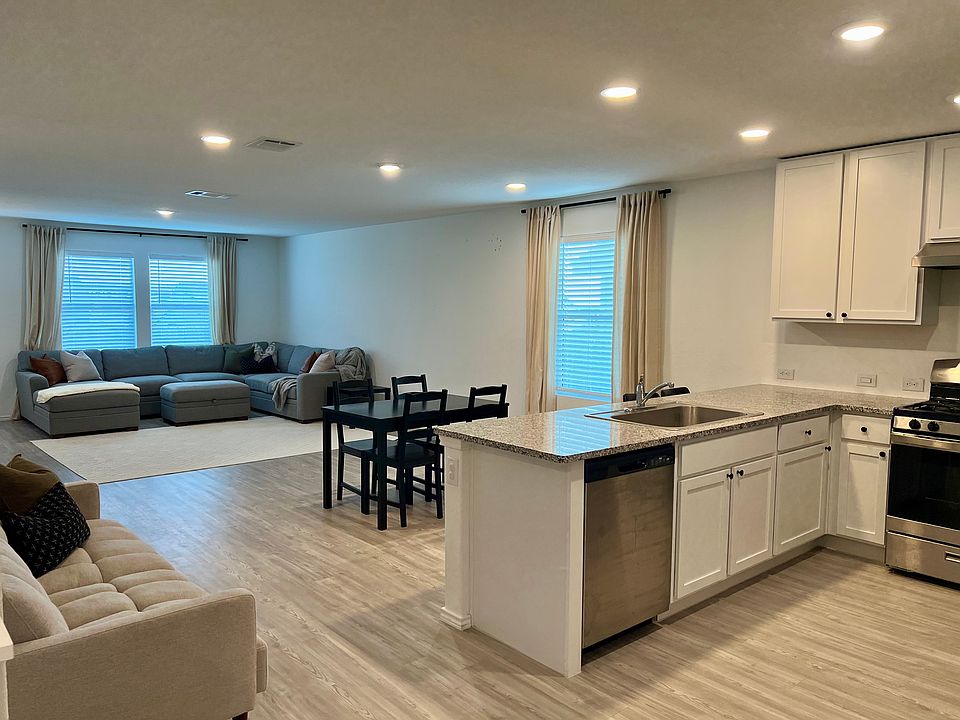 The open floor plan has ample natural light due to large windows with treatments plus upgraded recessed lighting.