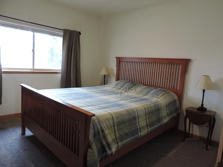 Second bedroom with blackout curtains and mini-blinds.