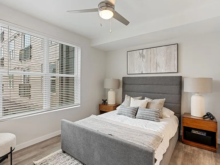 Spacious Bedroom With Ceiling Fan And Large Windows