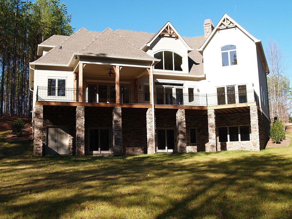 Back view of home, large deck and patio span the entire width of the home