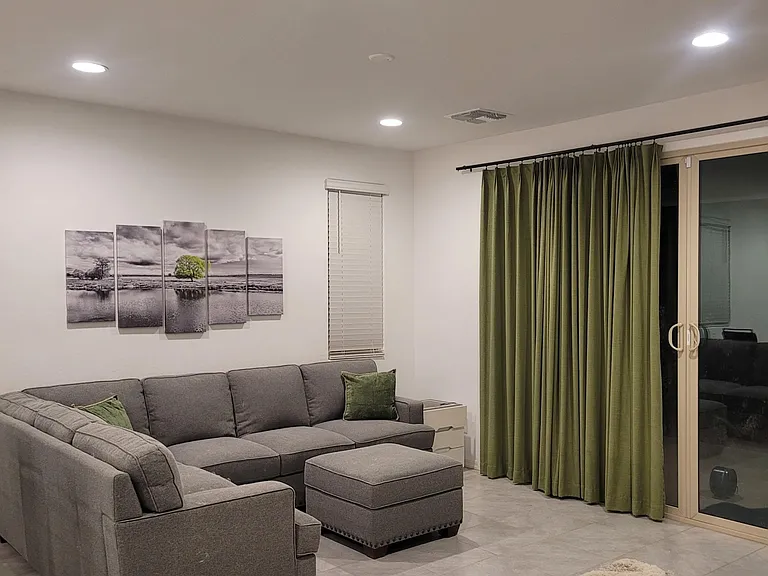 Spacious living area with a sectional and ottoman, plus sliding glass doors for easy outdoor access and natural light.