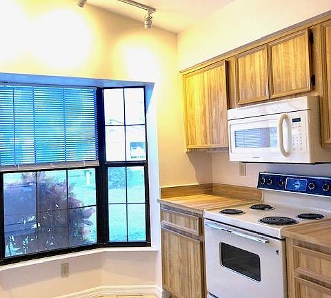 Bay window facing east in the kitchen, microwave over stove/oven; lots of cabinet storage.